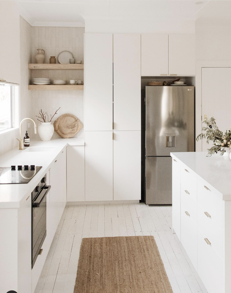 White Cabinet Above a Stainless Steel Fridge