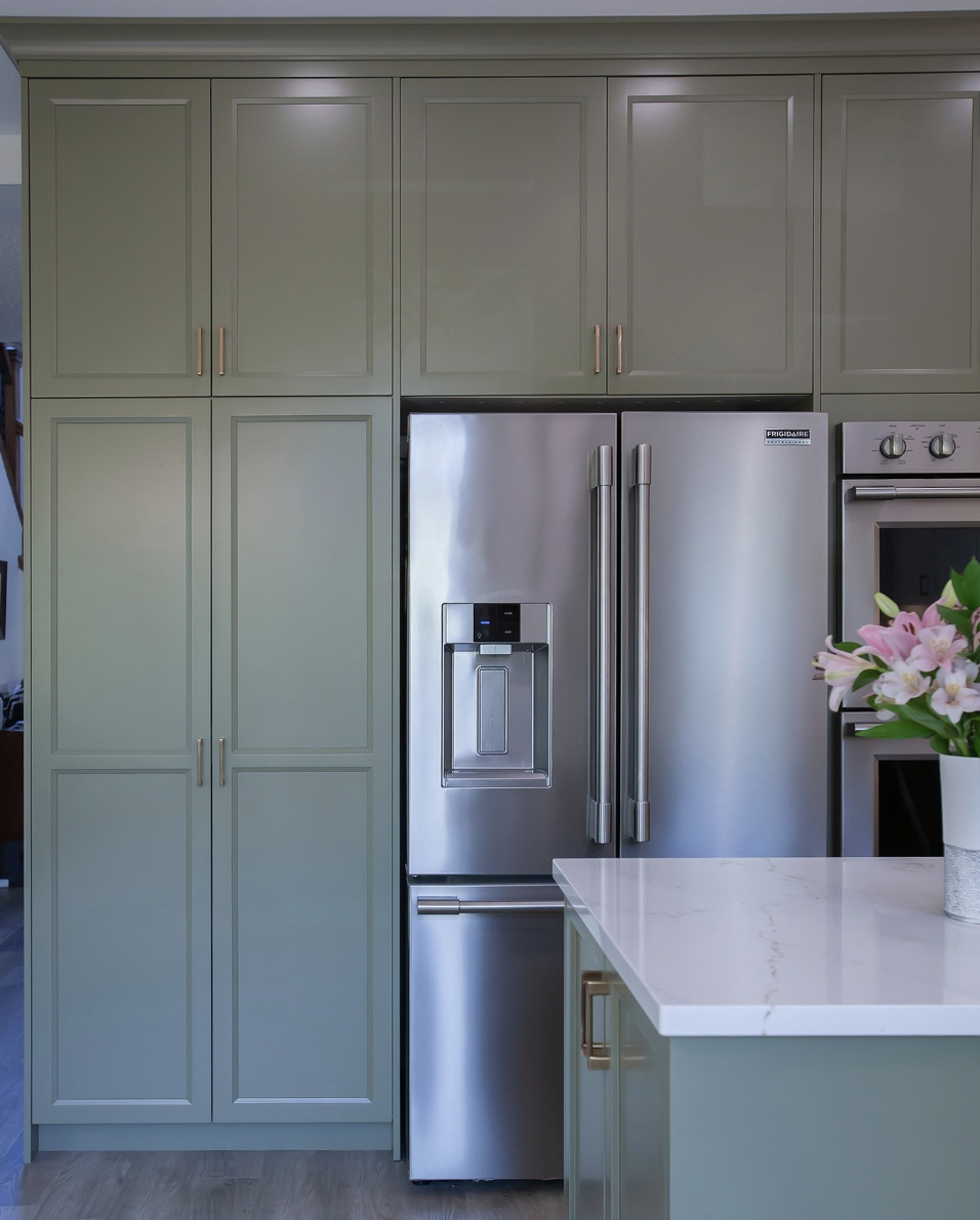Green Cabinets Over the Refrigerator With Gold Hardware