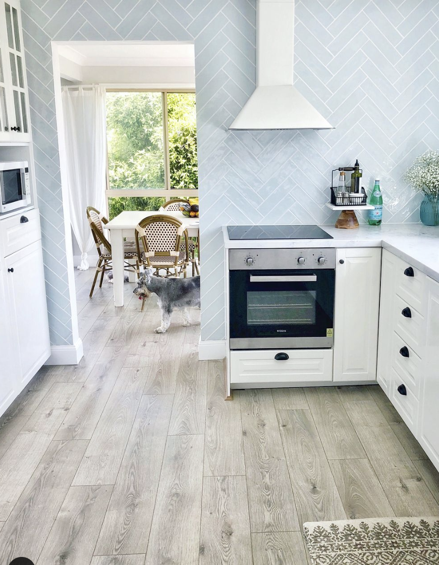 White-Grouted Herringbone Backsplash in Grey