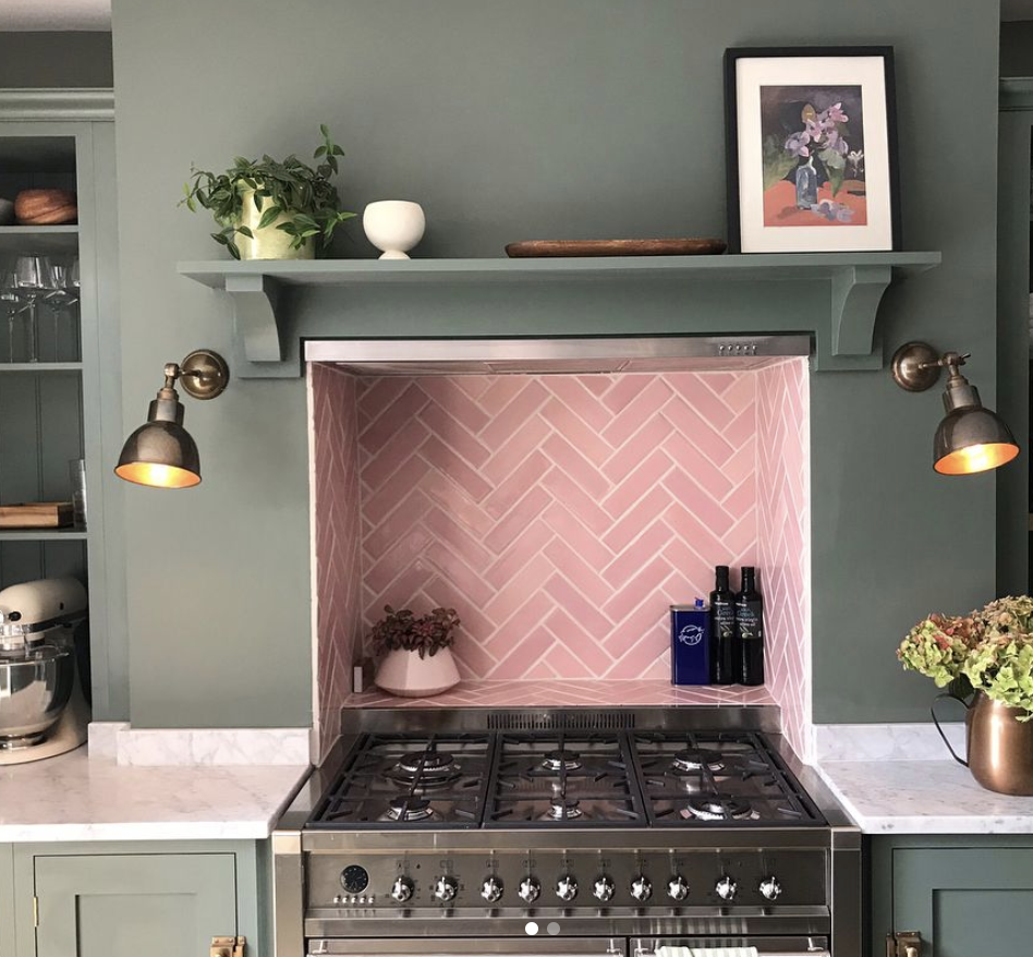 Kitchen With a Green Accent Wall and Pink Herringbone Tile