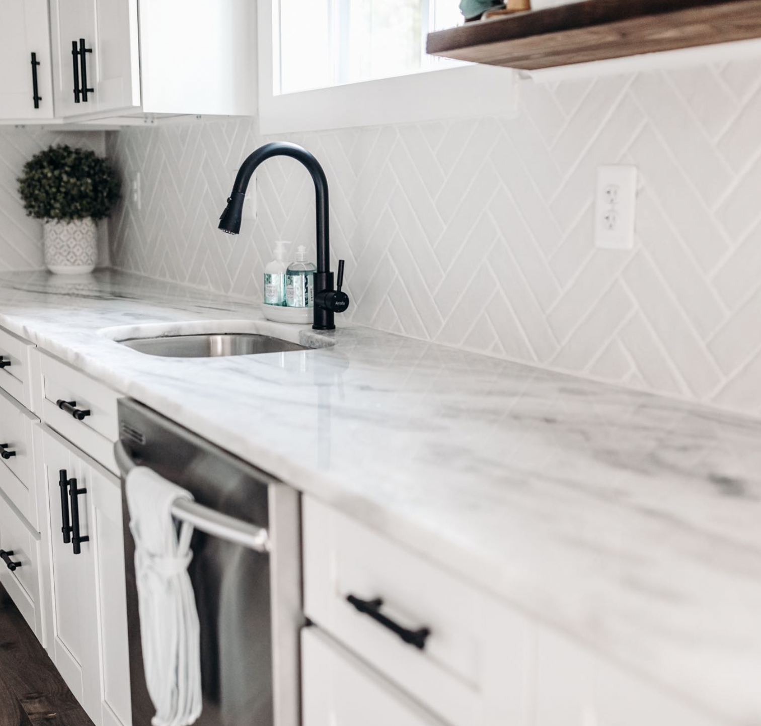White Tiles in a Herringbone Layout With Black Grout
