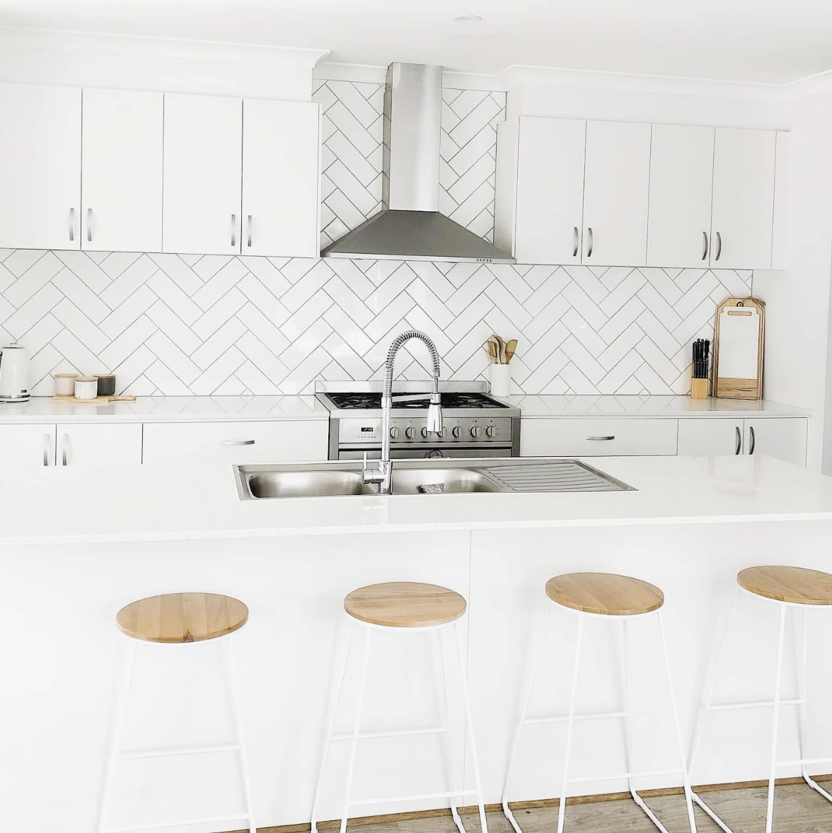White Kitchen Featuring a Herringbone Tile Backsplash