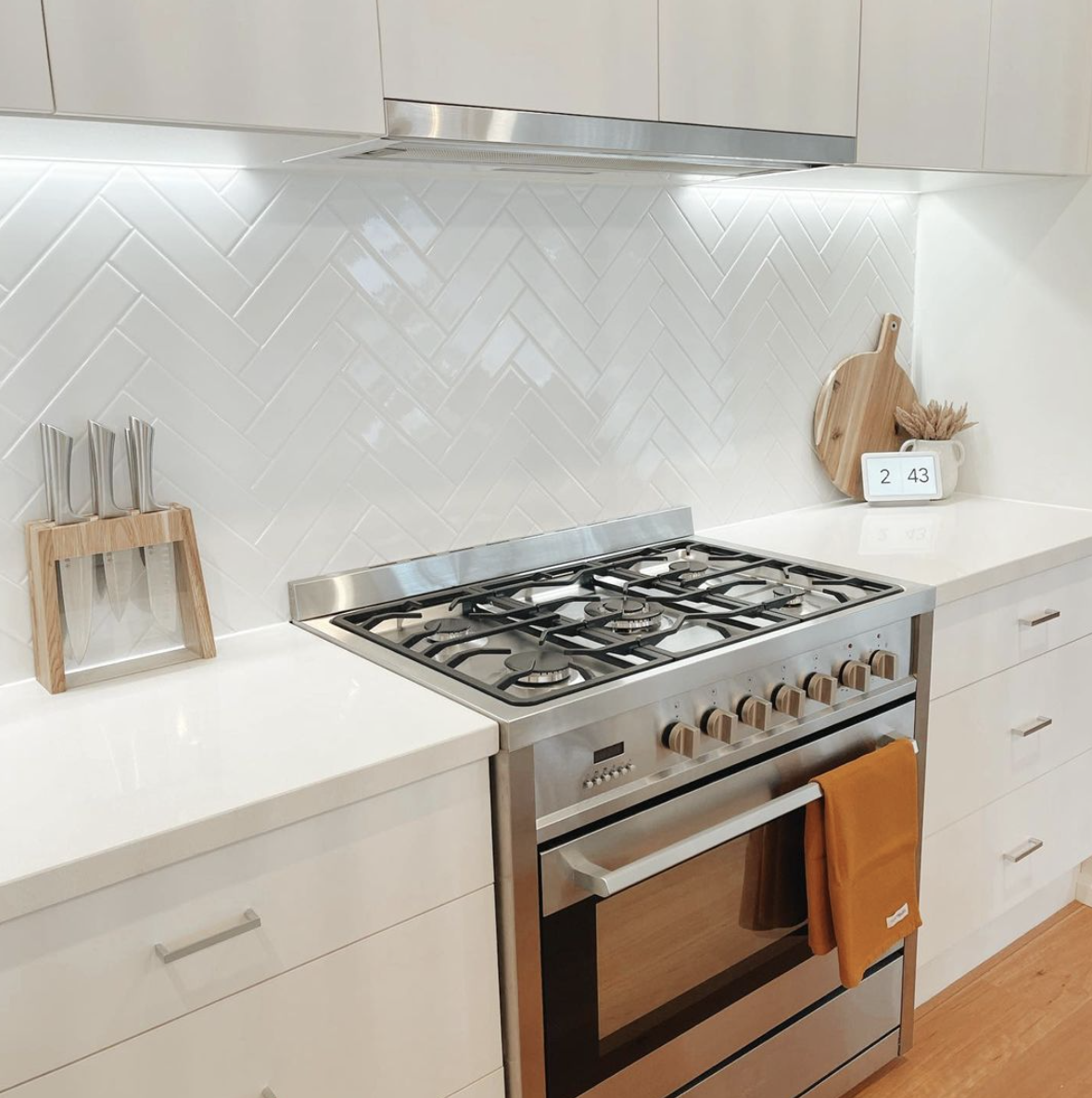 White Kitchen with Stainless Steel Appliances and Light Wood Floors