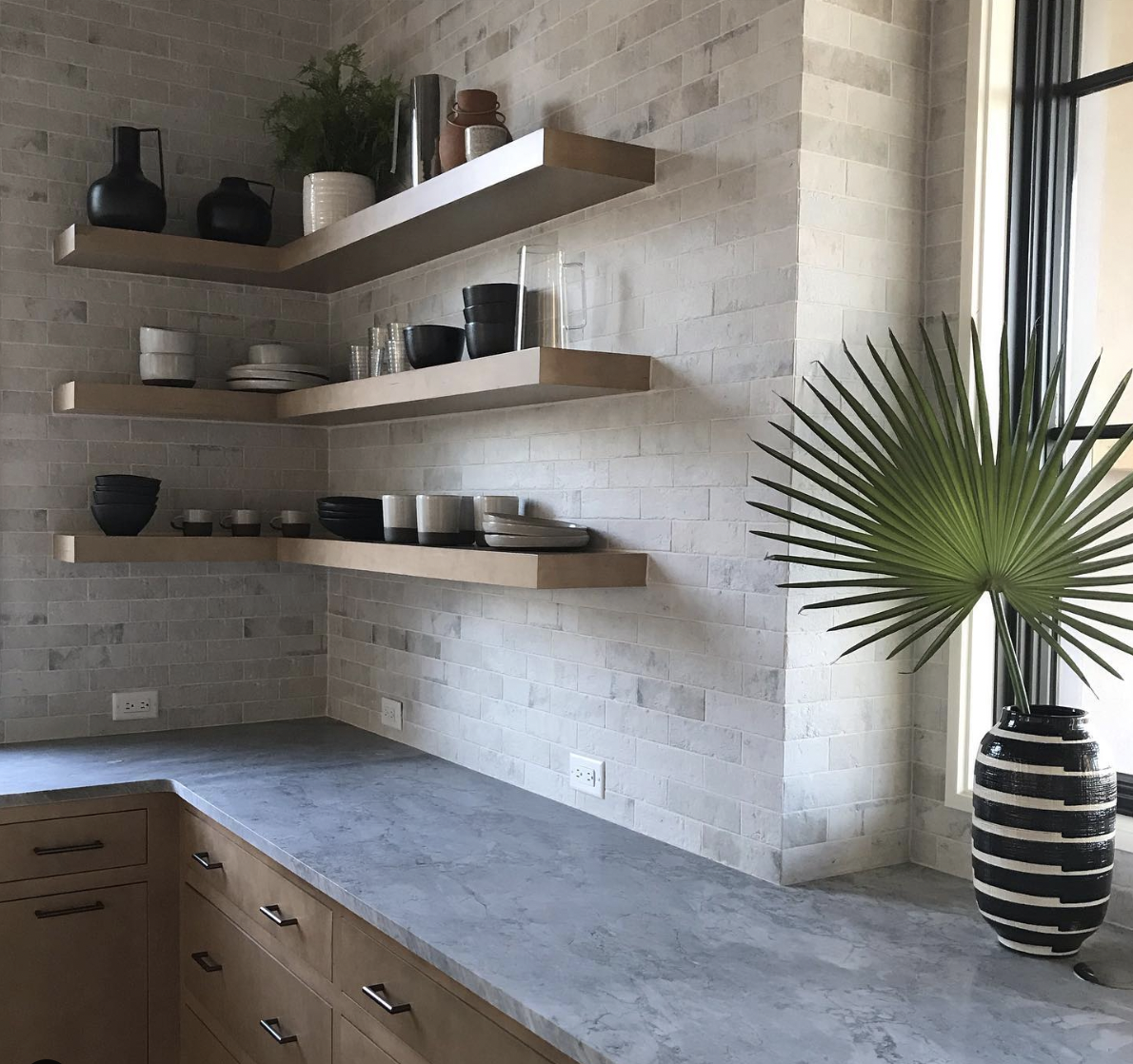Beige Brick Wall Backsplash Paired With Grey Countertops