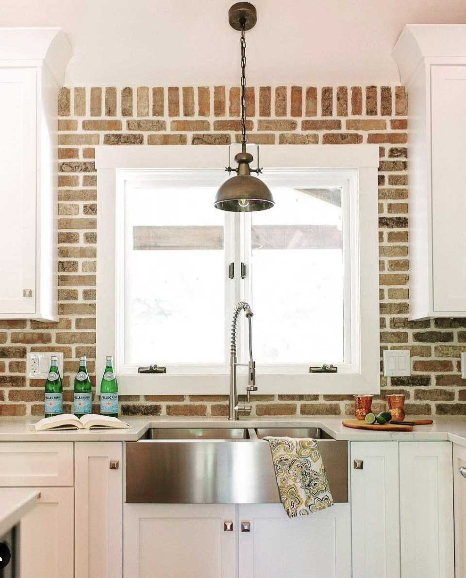 Kitchen Window Above the Sink With Solid Brick Backsplash