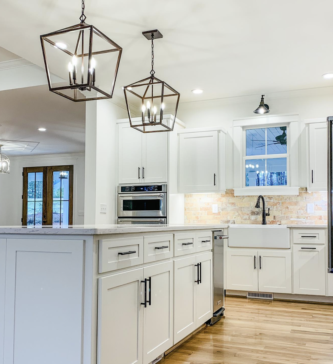 Brown Thin Brick Backsplash in a White Kitchen With Light Wood Flooring