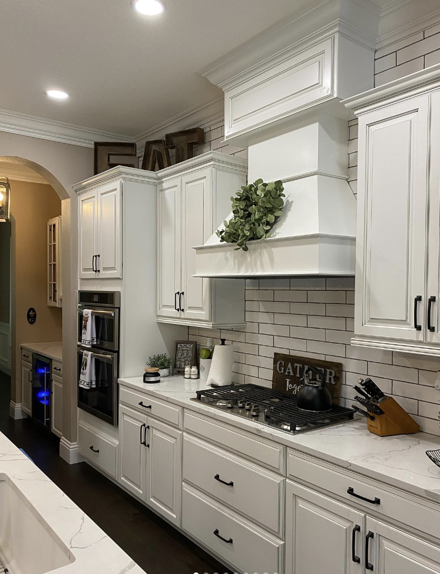 Crown-Molded White Kitchen Cabinets With Black Hardware