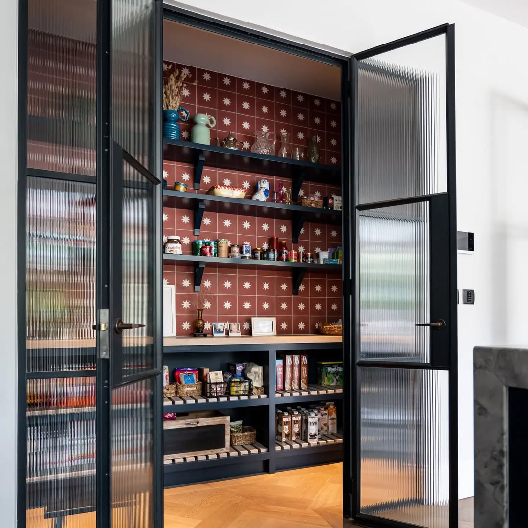 Kitchen Featuring Deep Blue Cabinetry and a Tempered Glass Pantry Door